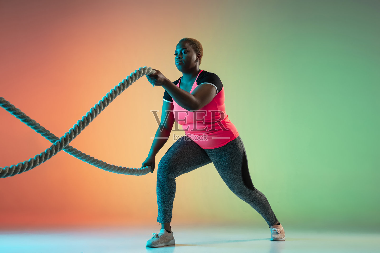 年轻的非洲裔美国大码女模特的梯度背景训练照片摄影图片