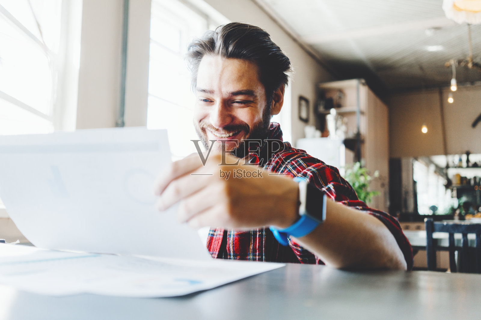 留胡茬的年轻男人在办公室看计划书照片摄影图片