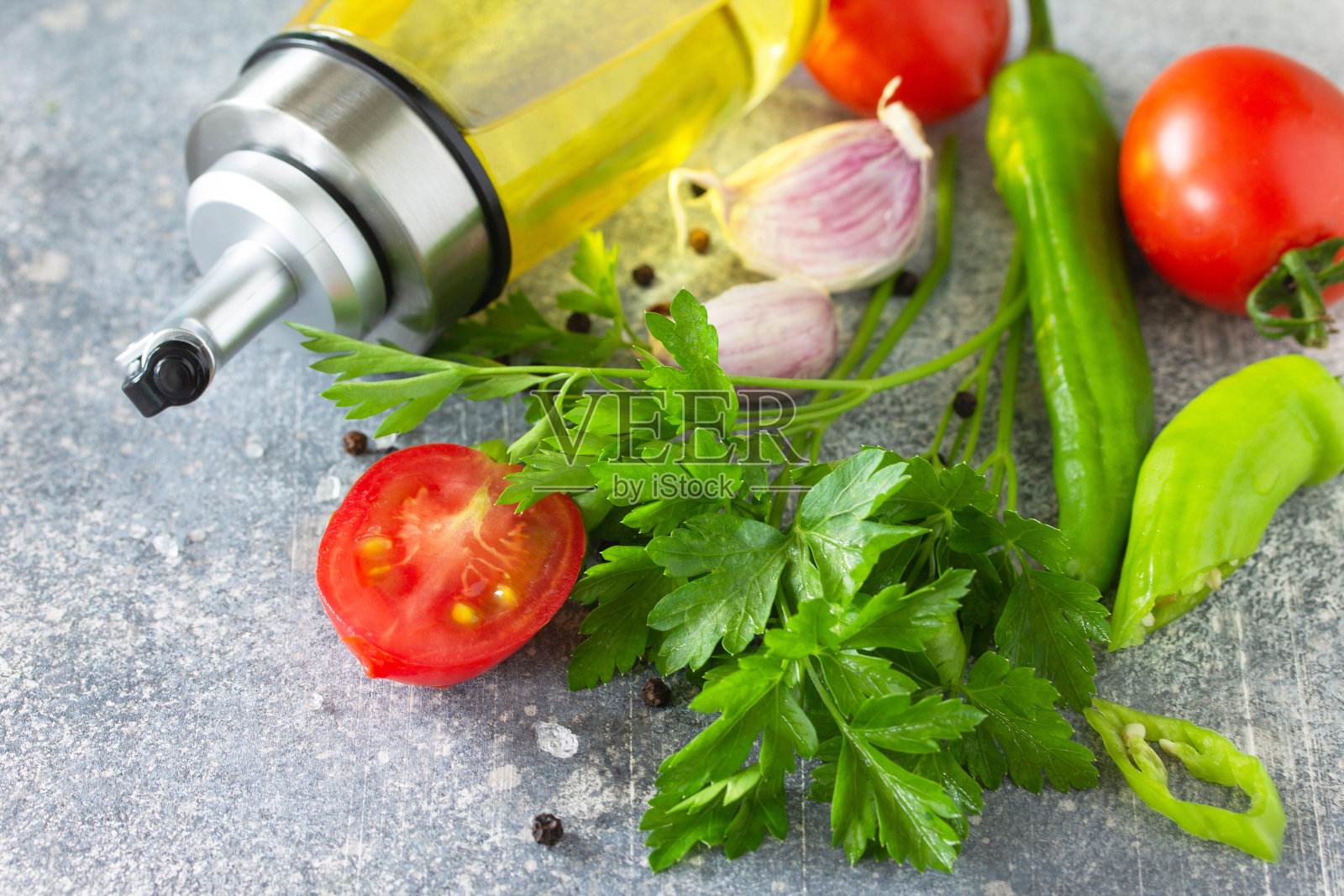 背景香料，香草和绿色蔬菜。石头桌上放着精选的香料、香草和橄榄油。照片摄影图片