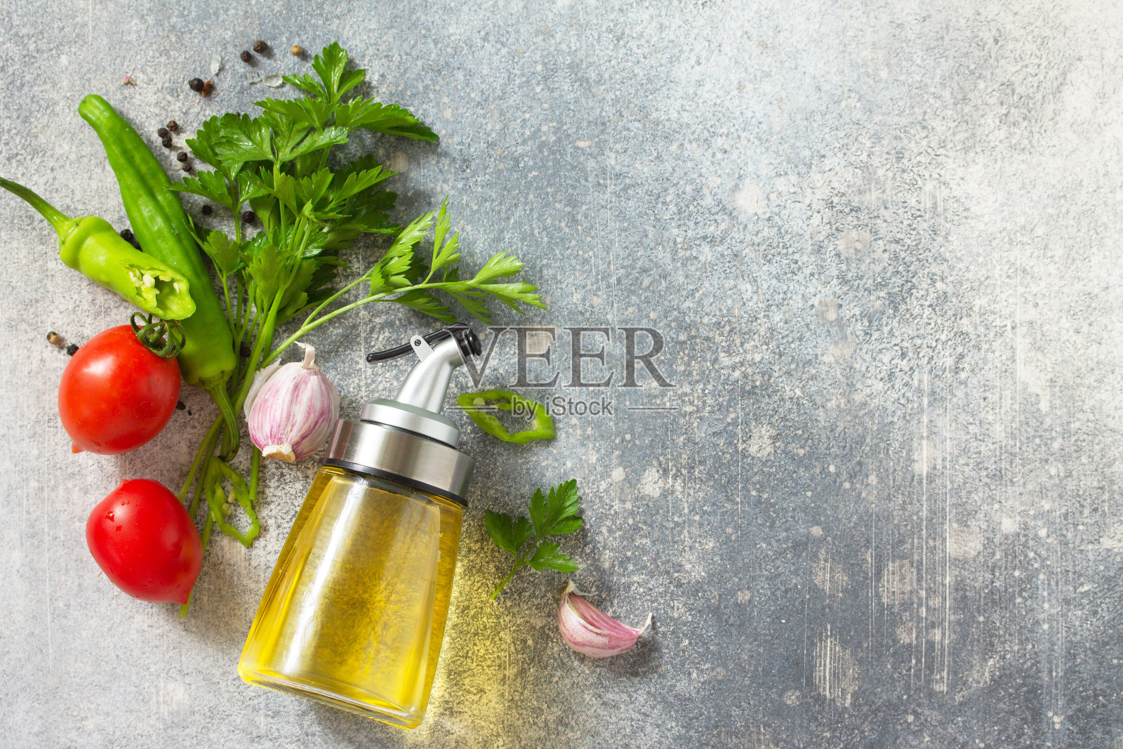 背景香料，香草和绿色蔬菜。石头桌上放着精选的香料、香草和橄榄油。俯视图平铺背景。副本的空间。照片摄影图片