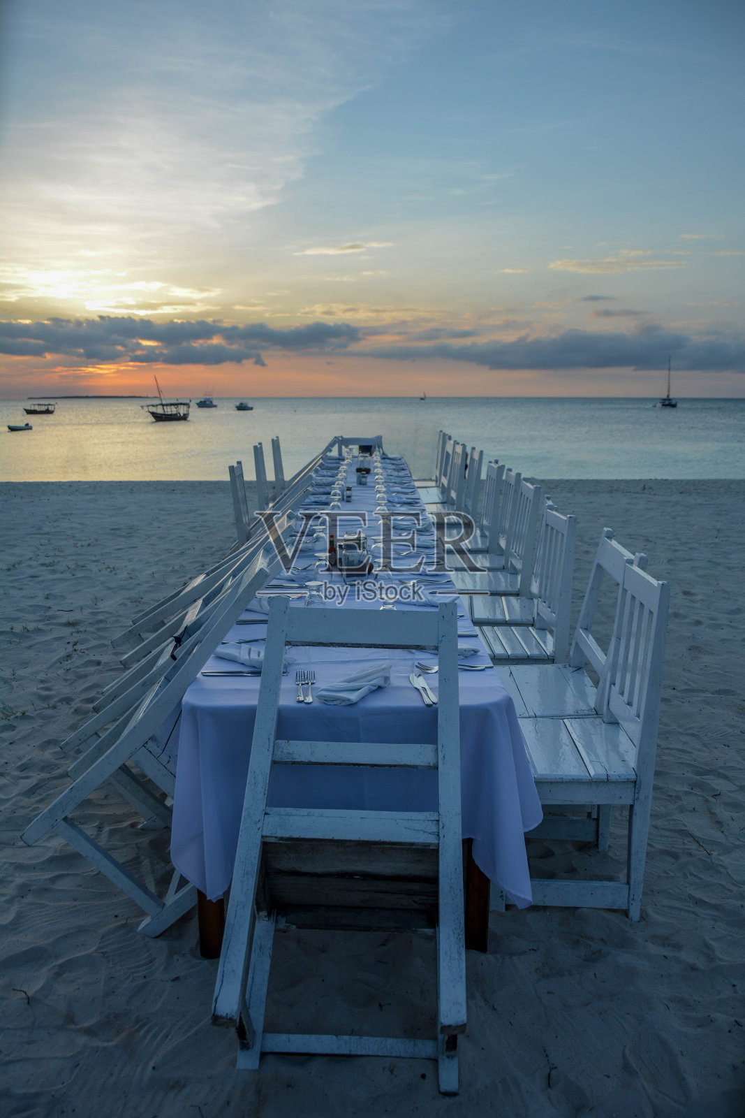 日落时分在海滩上用餐的优雅餐桌照片摄影图片