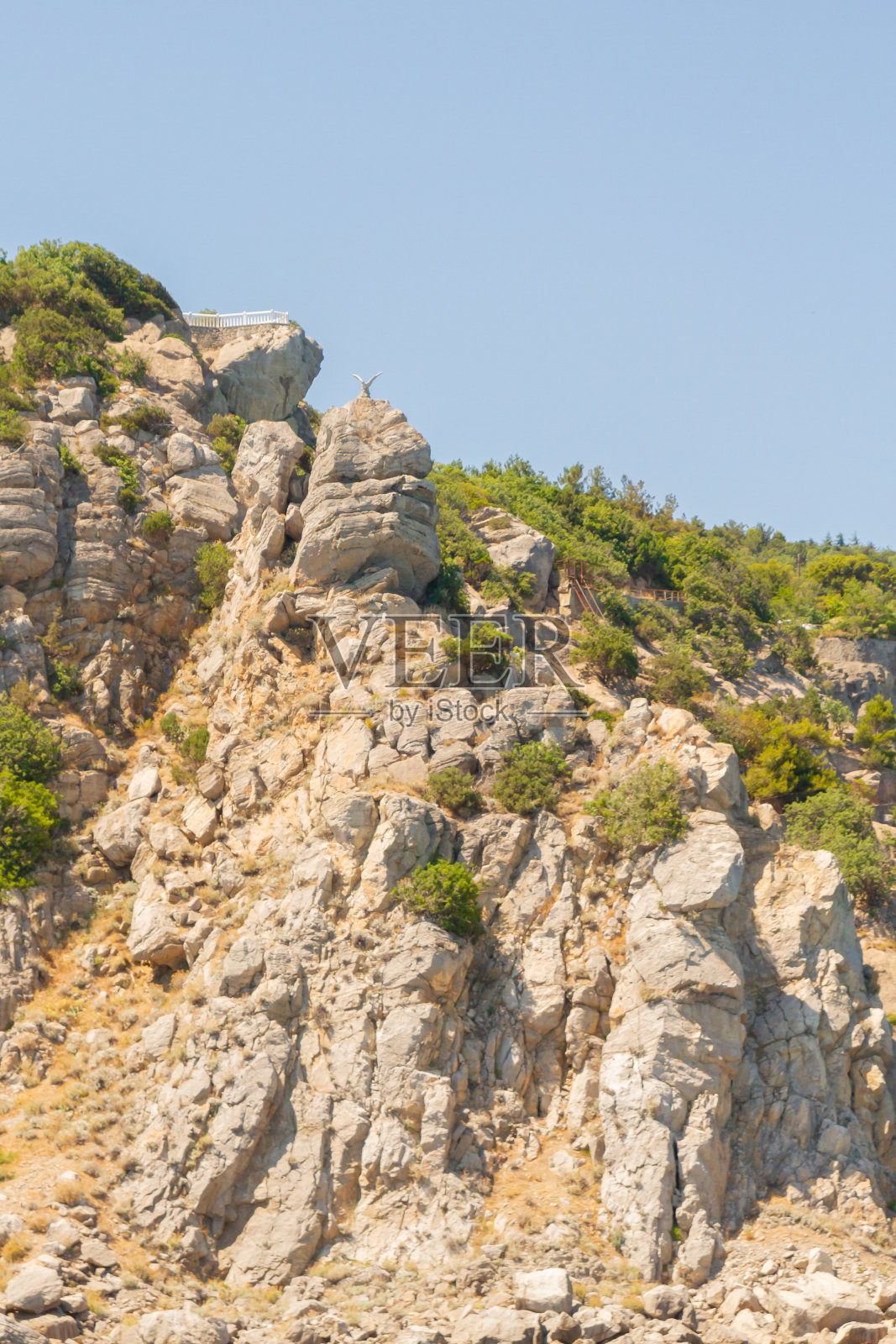 在夏天的一个阳光明媚的日子里，海滩上的山脉和岩石照片摄影图片