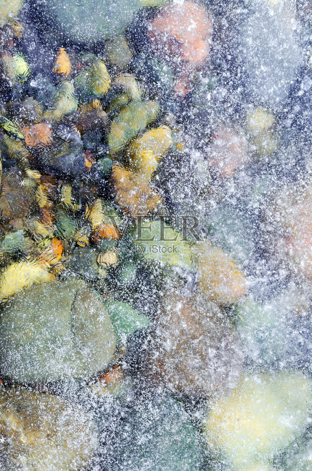 河石上覆盖着薄而透明的冰和雪，冰上有大的雪晶体，冰的纹理是垂直的照片摄影图片