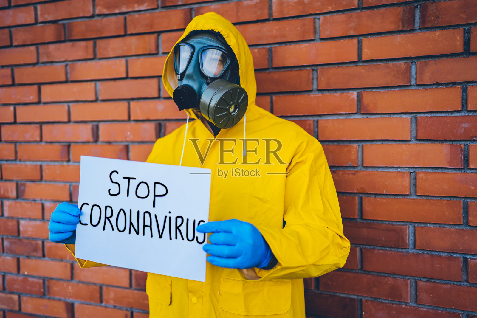 穿着防护服的人举着阻止冠状病毒的横幅照片摄影图片