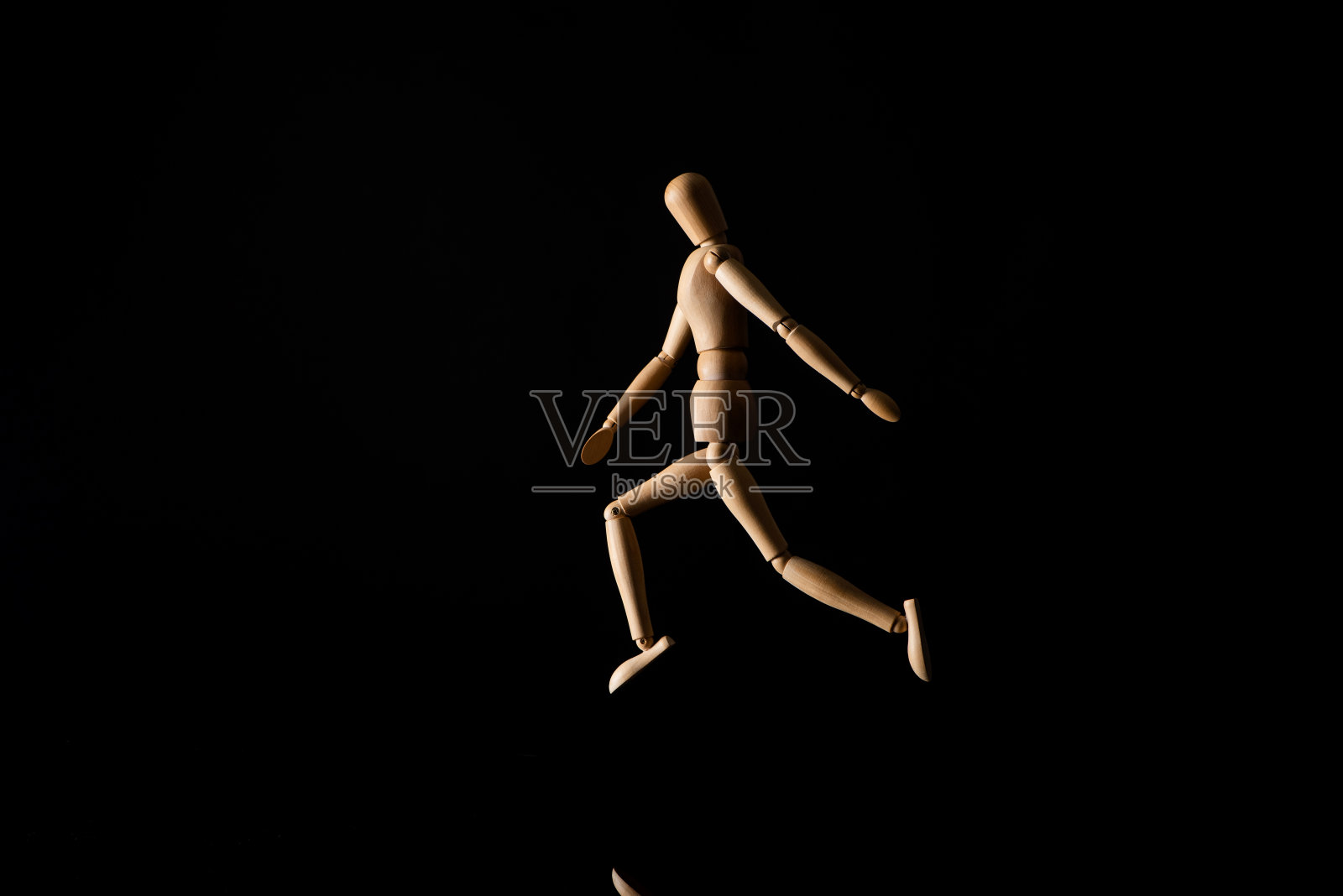 在黑色上模仿跑步的木制娃娃照片摄影图片