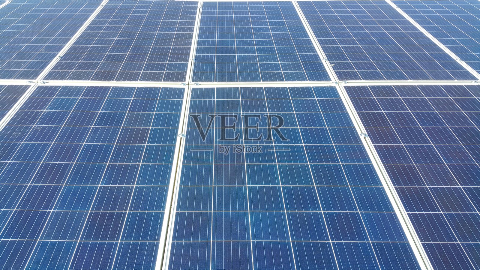 太阳能电池板安装在地面上，阳光洒落在上面，是环保的可再生能源照片摄影图片