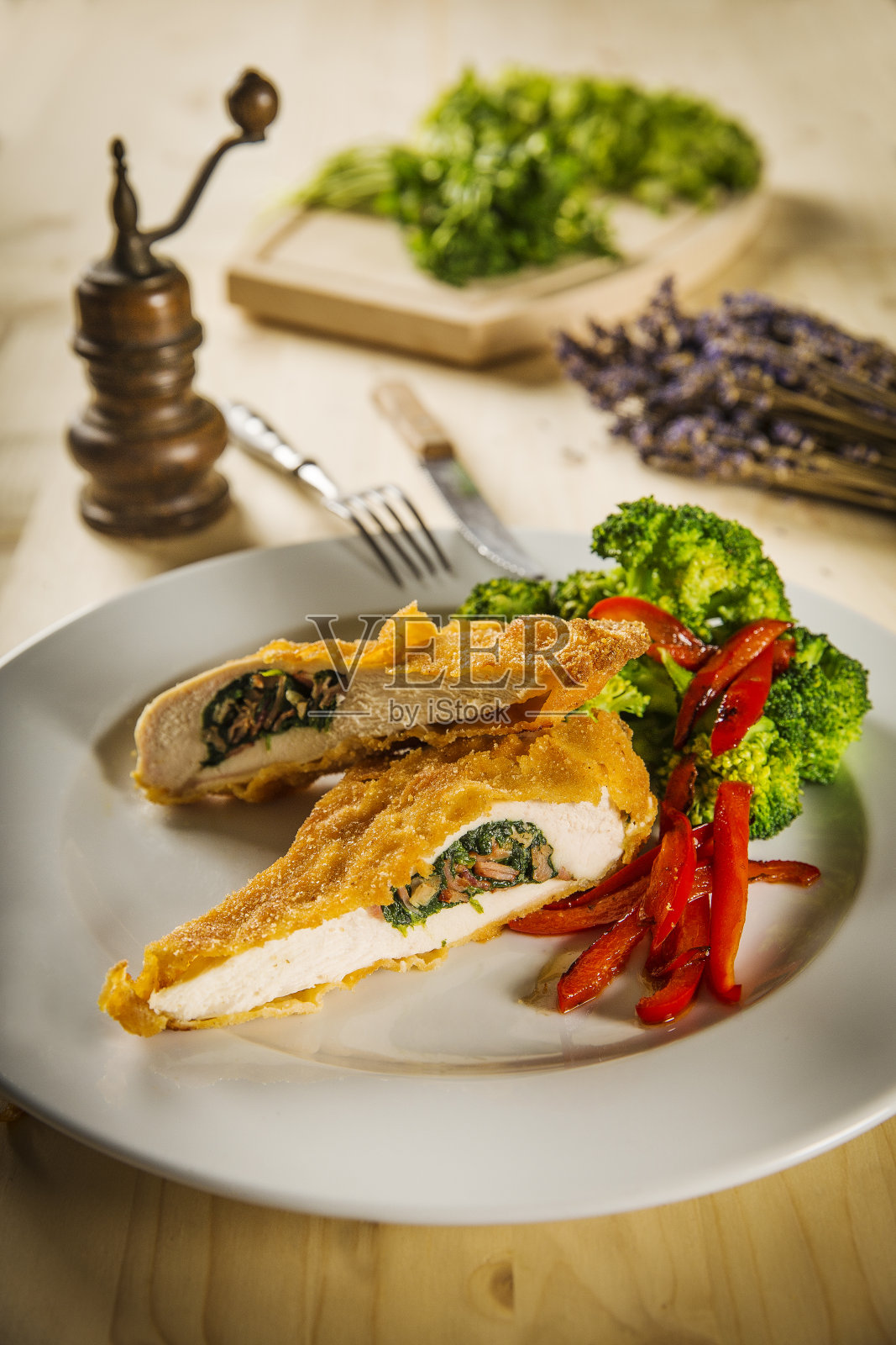 特写基辅鸡与蒸西兰花和烤辣椒白照片摄影图片