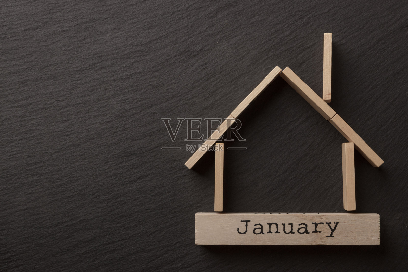 黑色背景上的房子形状的原木照片摄影图片