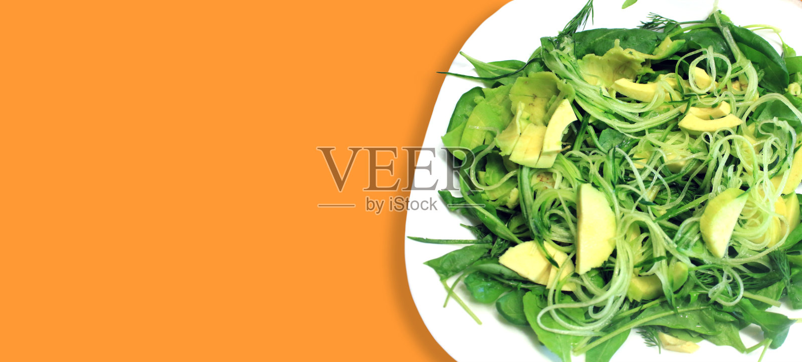 生机纯素的食物。蔬菜沙拉，新鲜蔬菜，鳄梨，黄瓜，芝麻菜，菠菜，特写照片摄影图片