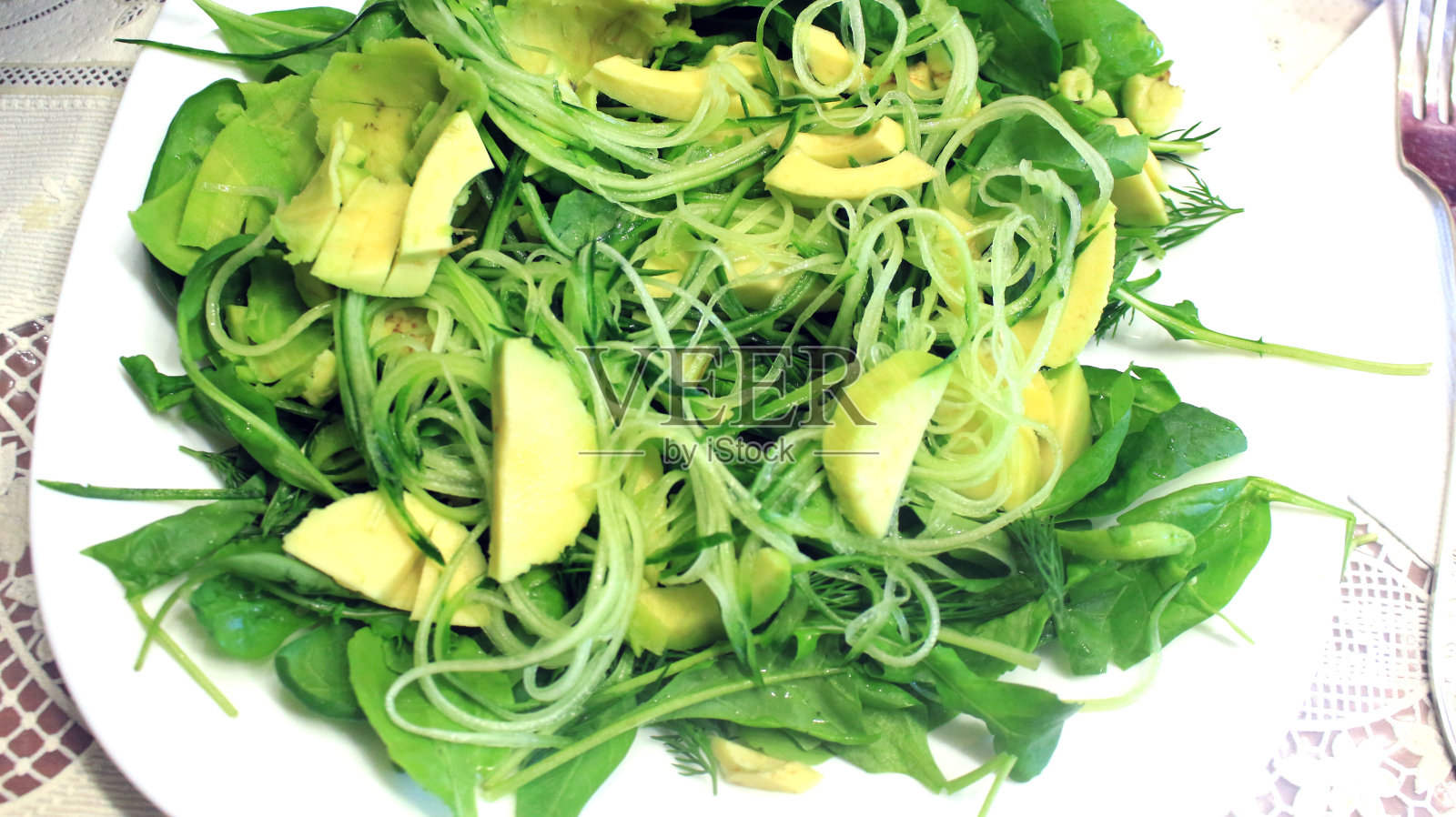 生机纯素的食物。蔬菜沙拉，新鲜蔬菜，鳄梨，黄瓜，芝麻菜，菠菜，特写照片摄影图片