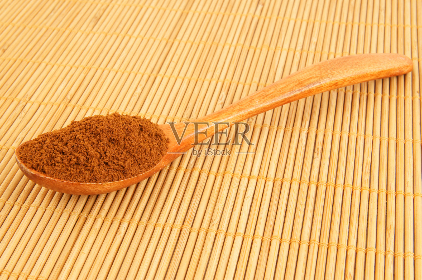 用勺子装速溶咖啡，放在竹制的餐垫上照片摄影图片