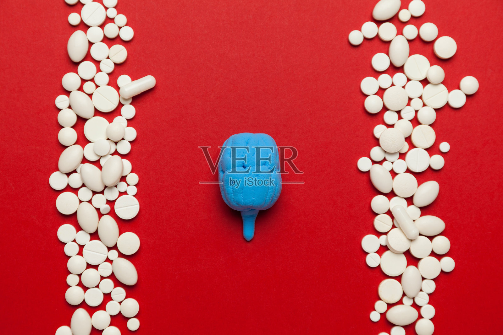 红色背景上有药片的人脑。焦虑、抑郁和神经障碍。治疗精神分裂症、阿尔茨海默病和帕金森病照片摄影图片