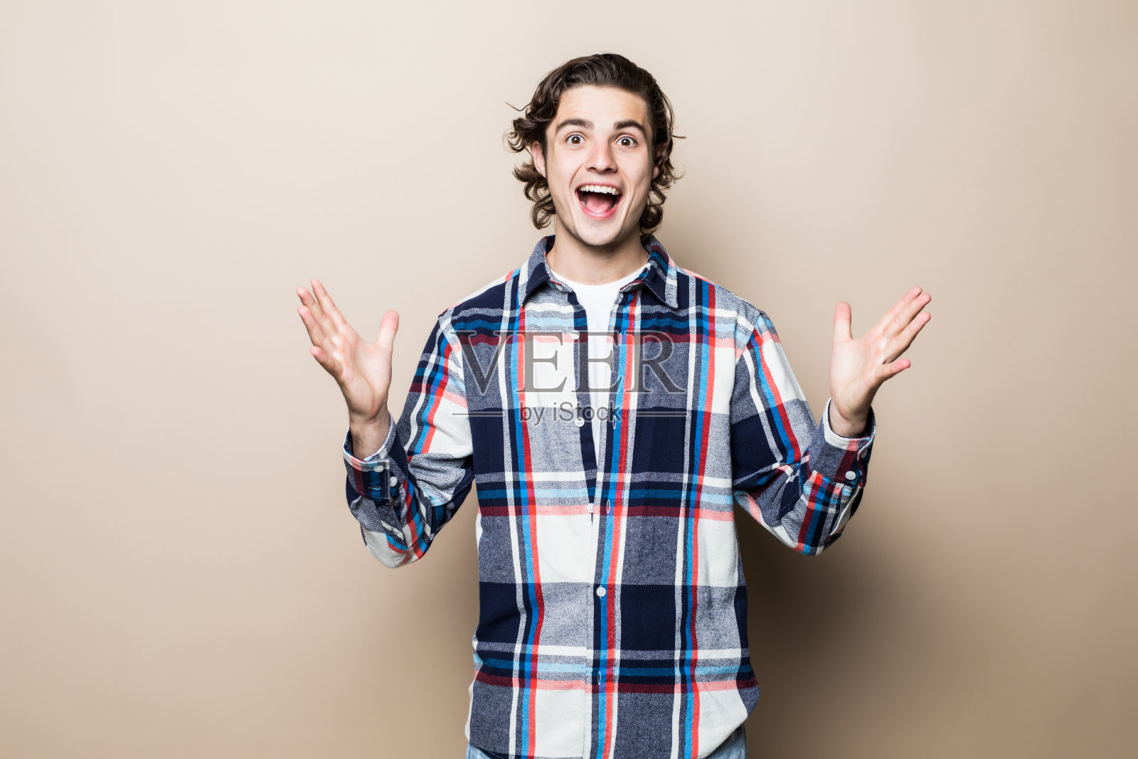 年轻男人双手张开米色背景照片摄影图片