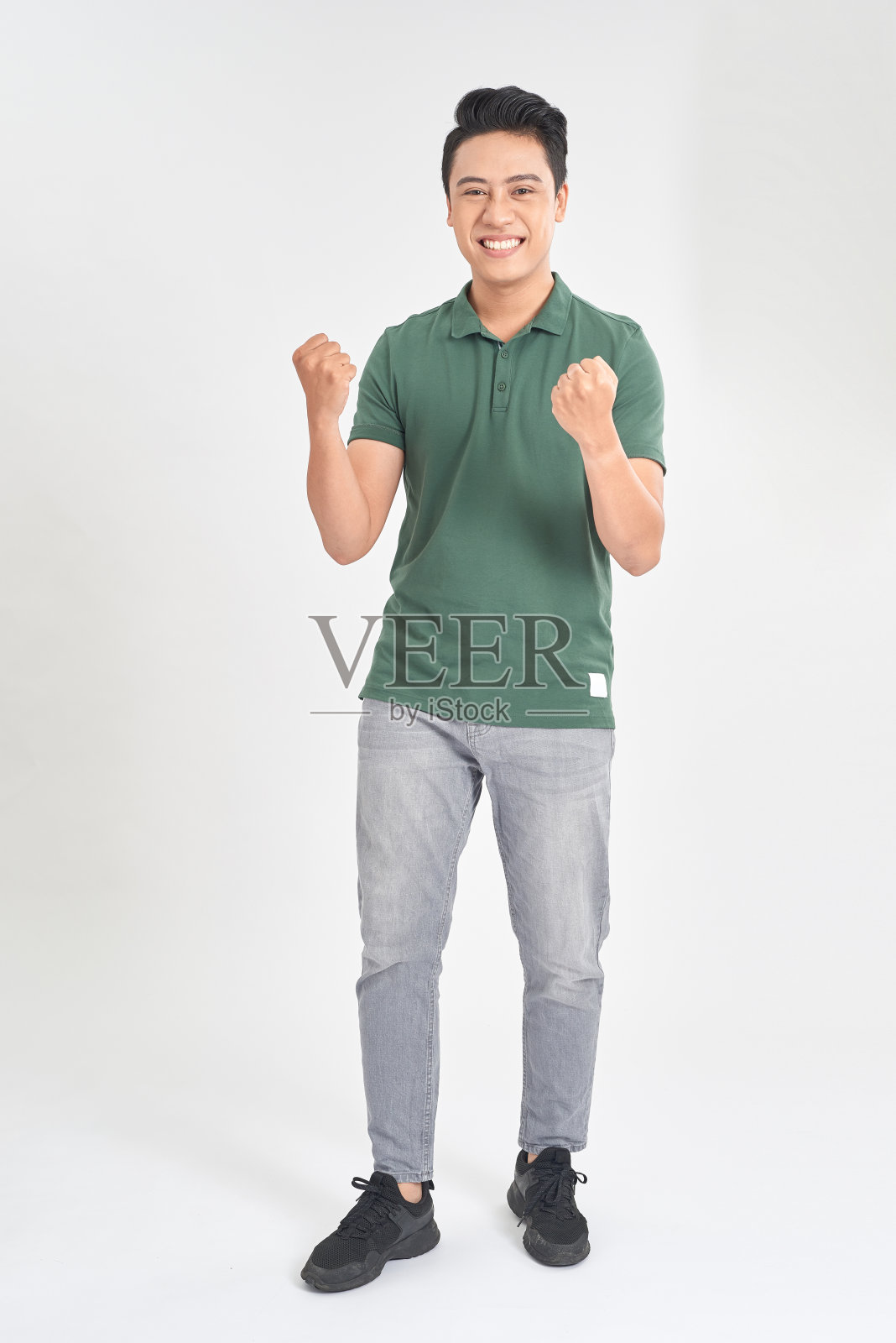 一个兴奋的年轻人庆祝成功的肖像，两个拳头在空中孤立的白色背景照片摄影图片