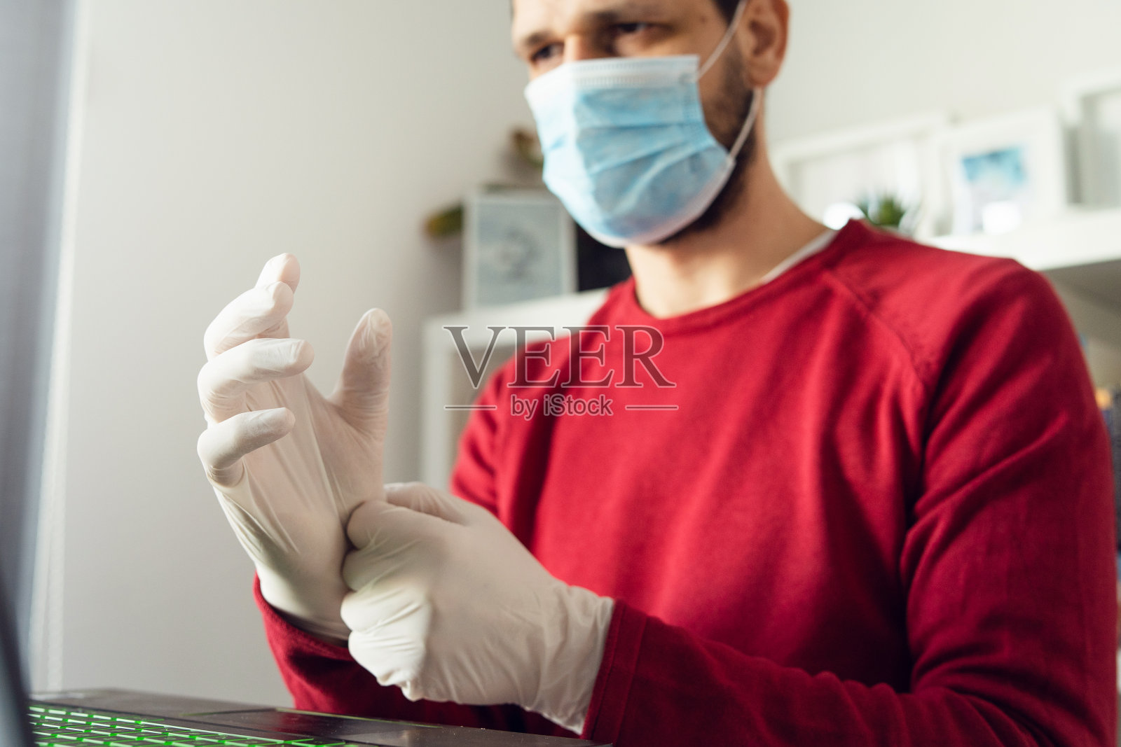 成年白人男子戴口罩和橡胶手套，预防病毒细菌传播，在办公室工作侧面照照片摄影图片