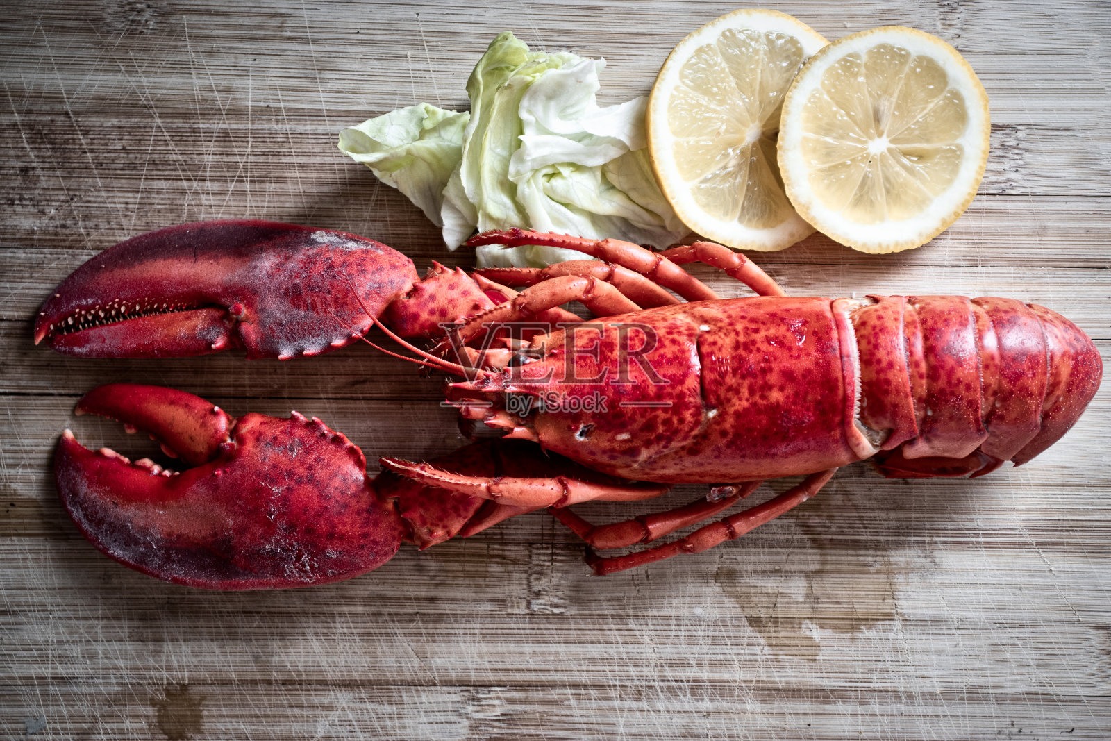 红龙虾配蔬菜和柠檬木切板背景，俯视图/龙虾晚餐照片摄影图片