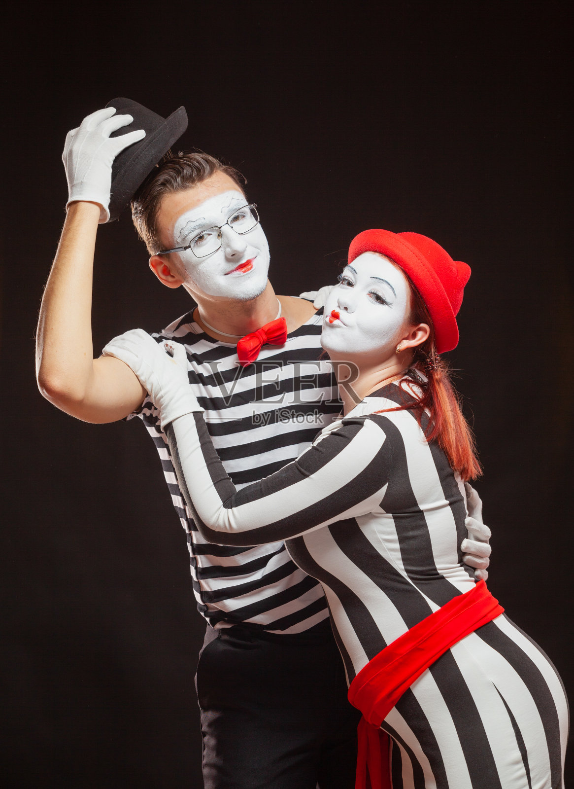 两位哑剧演员的表演，黑色背景，象征友谊照片摄影图片