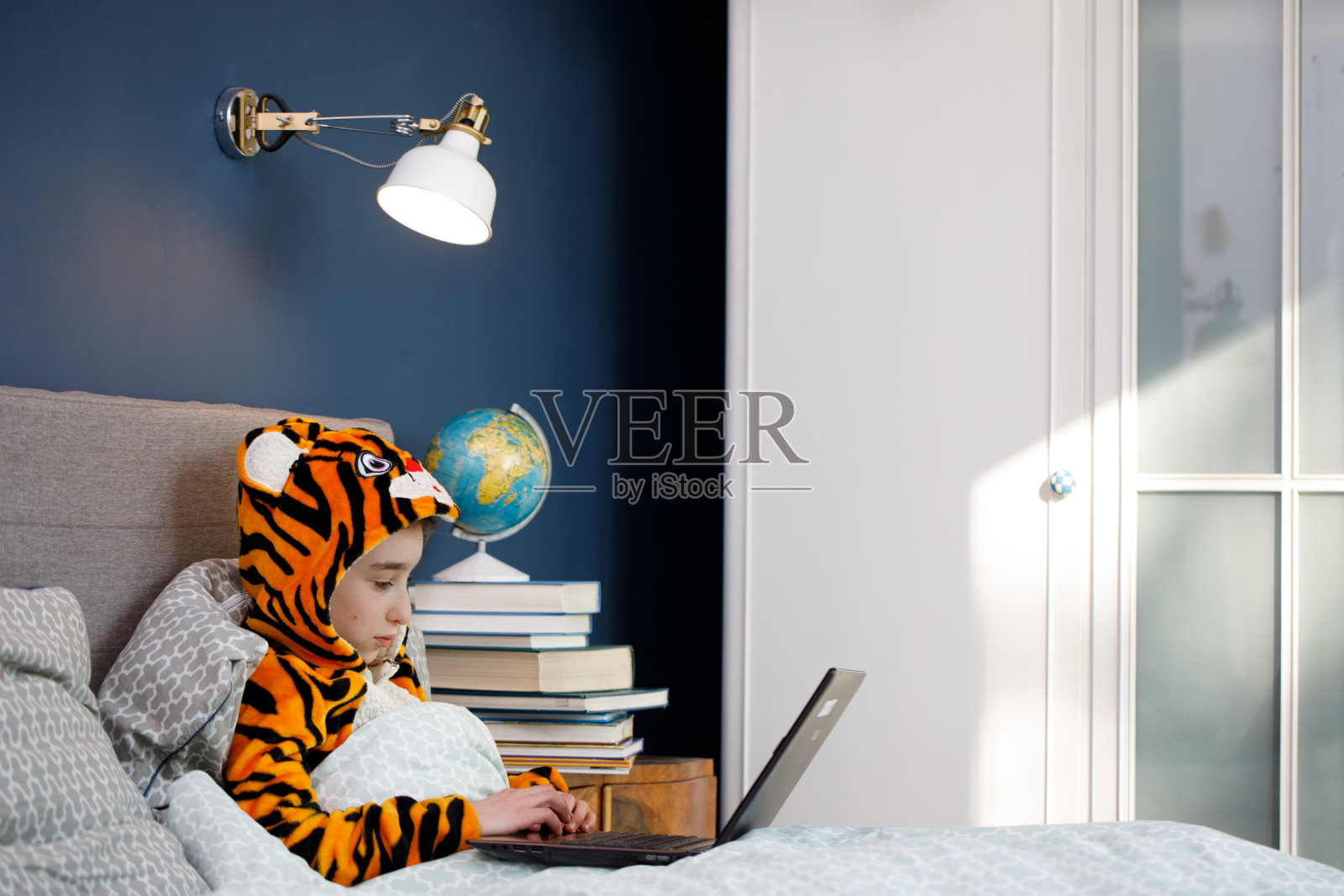 疫情隔离期间的远程在线学习：学生在家用笔记本电脑学习照片摄影图片