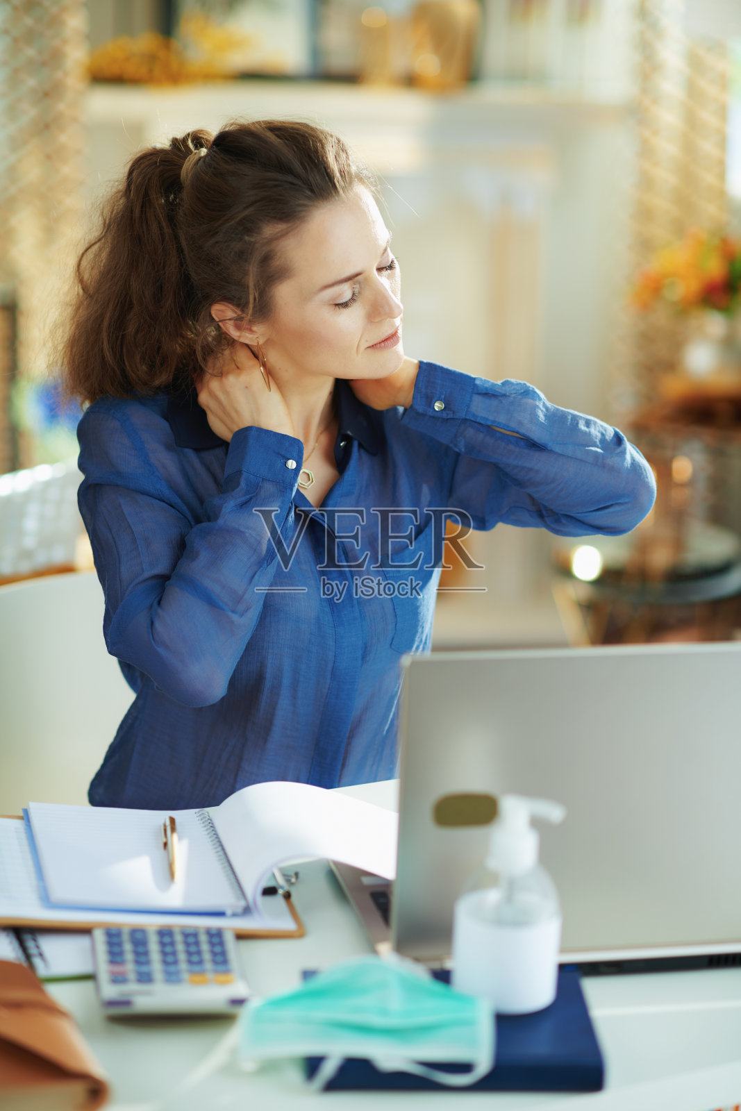 阳光明媚的日子里，疲惫的时尚女性在家中感到颈部疼痛照片摄影图片