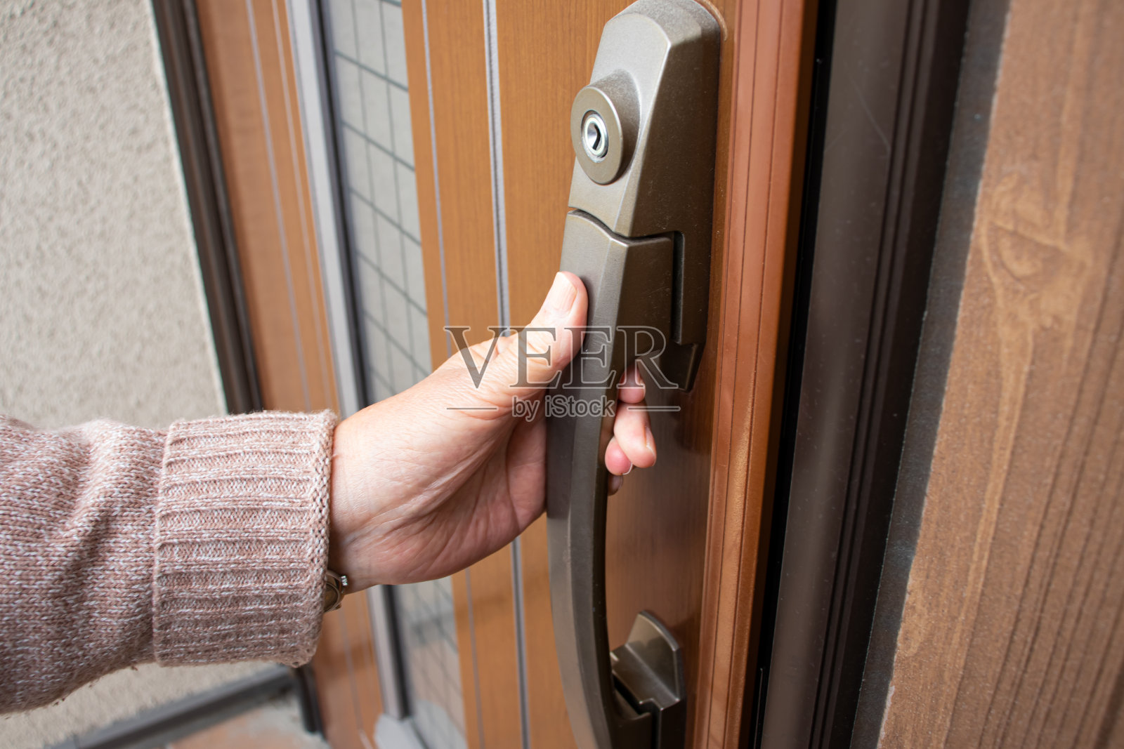 有前门的老妇人。照片摄影图片