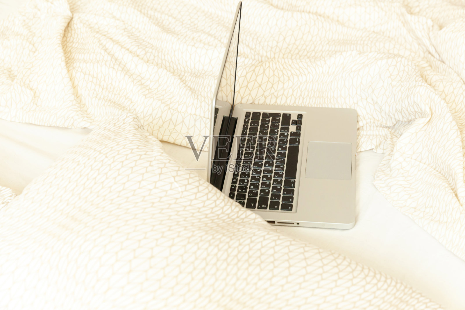 家庭移动办公室。在卧室的床上放置笔记本电脑。舒适的现代工作空间为自由职业者或学生在室内学习。自由商业检疫概念照片摄影图片