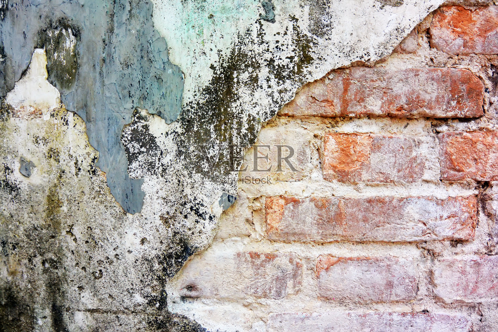 旧的橙色砖墙，灰泥已经掉落照片摄影图片