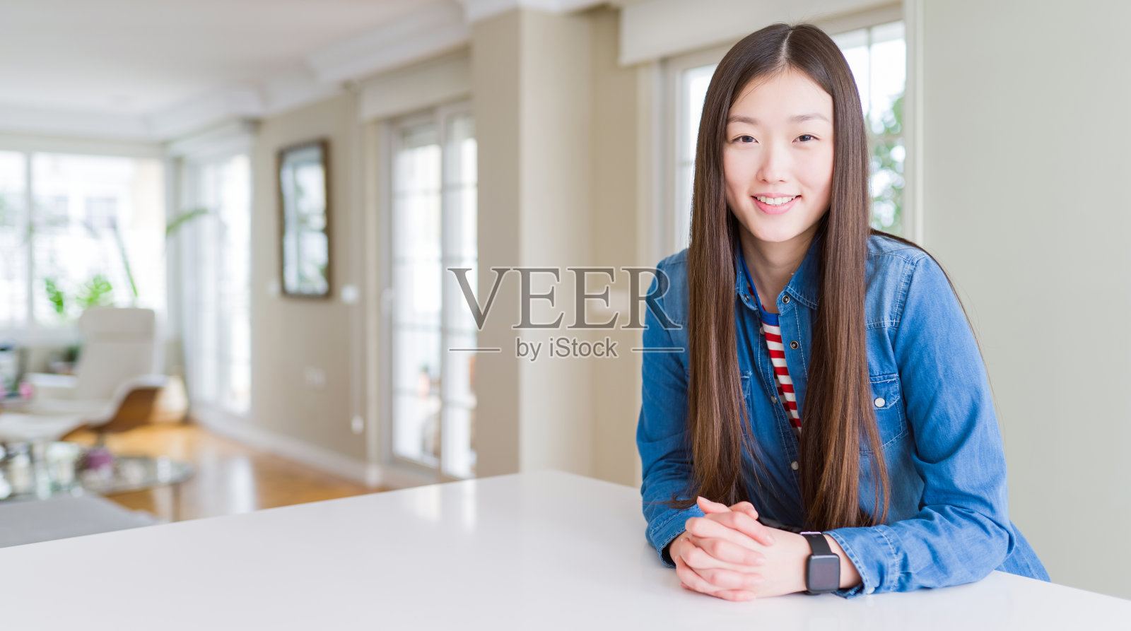 年轻美丽的亚洲女子与长头发穿着牛仔夹克与快乐和凉爽的笑容在脸上。幸运的人。照片摄影图片