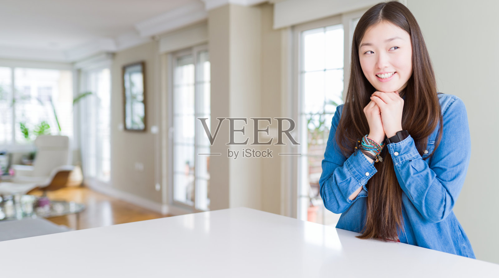 年轻美丽的亚洲女人长头发穿着牛仔夹克笑紧张和兴奋的手在下巴看向一边照片摄影图片