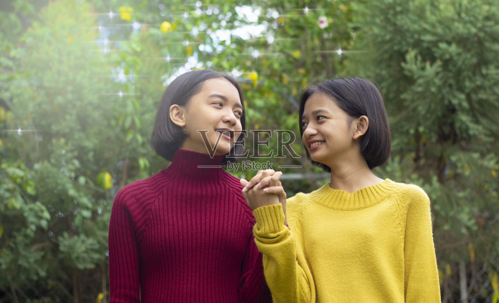 两名快乐的亚洲年轻女孩，绿色背景照片摄影图片