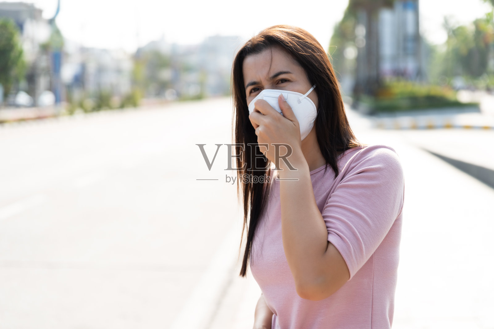 穿着西装戴着防护口罩的女人咳嗽，准备好对抗冠状病毒和PM2.5的特写照片摄影图片