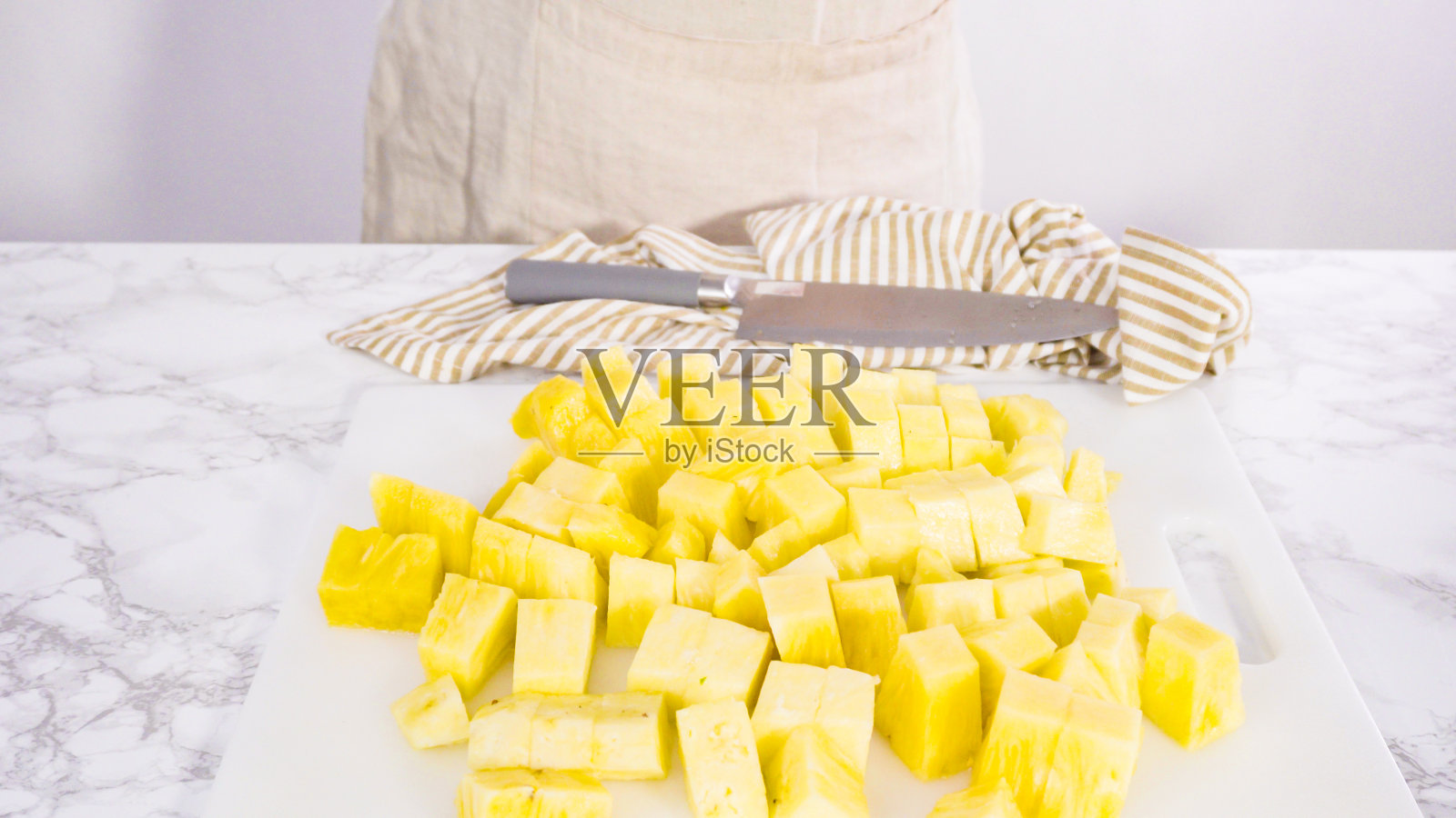 用白色砧板切菠萝。照片摄影图片