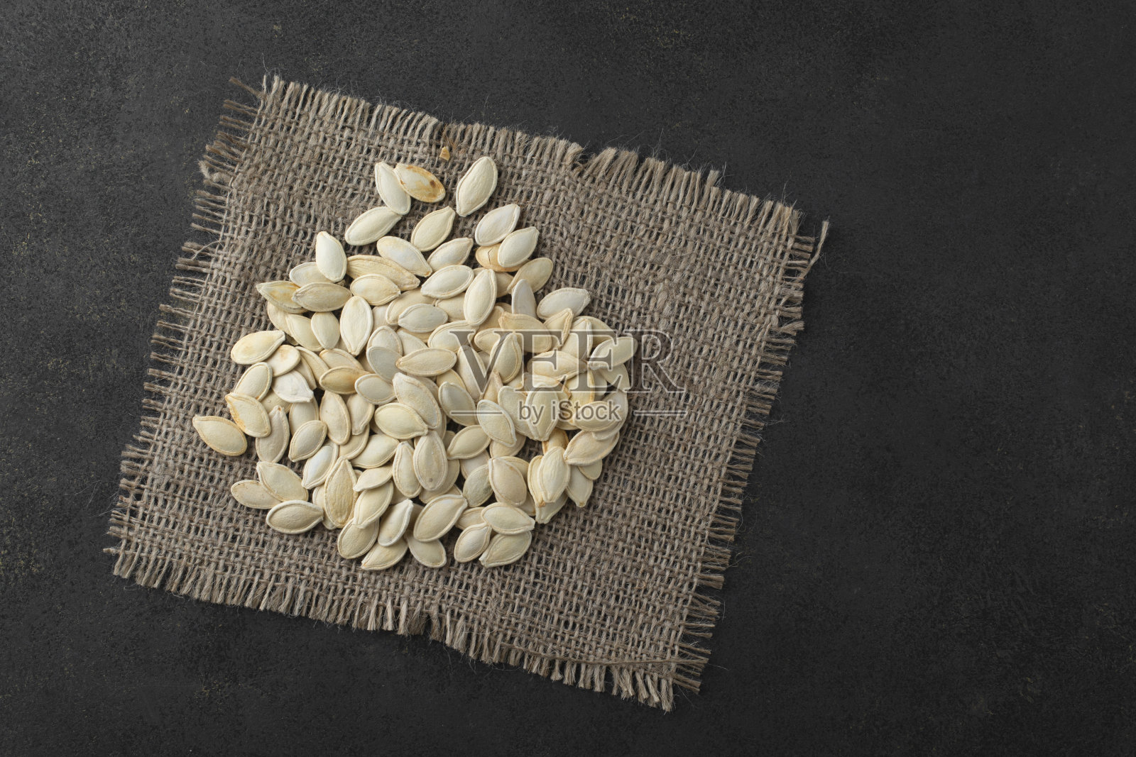 麻袋上的新鲜南瓜子。从以上观点。照片摄影图片