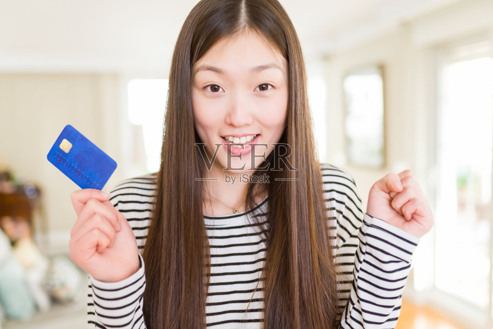 美丽的亚洲女人拿着信用卡尖叫自豪，庆祝胜利和成功非常兴奋，欢呼的情绪照片摄影图片