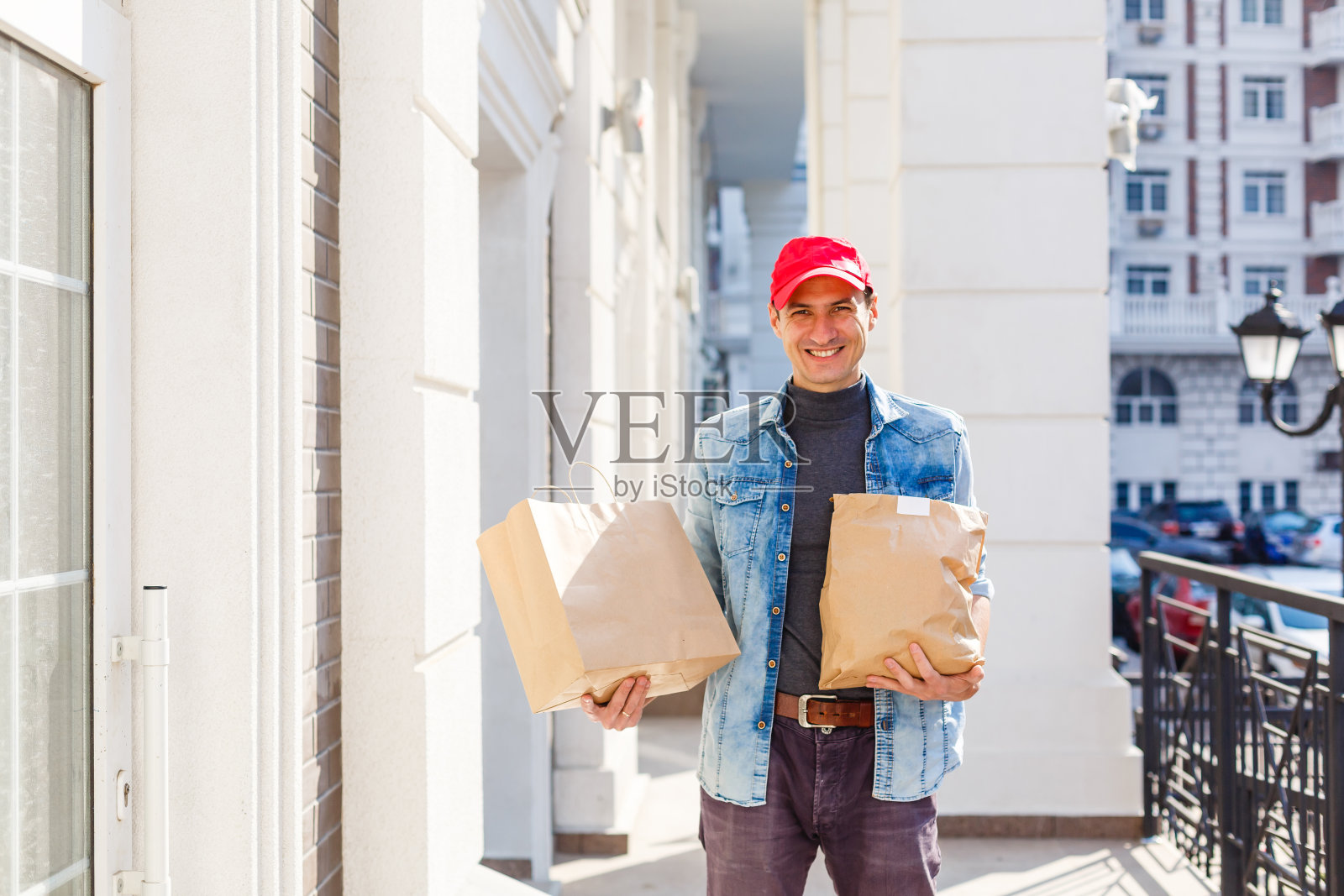 配送概念：男子将咖啡和食物用纸袋送到顾客家中照片摄影图片