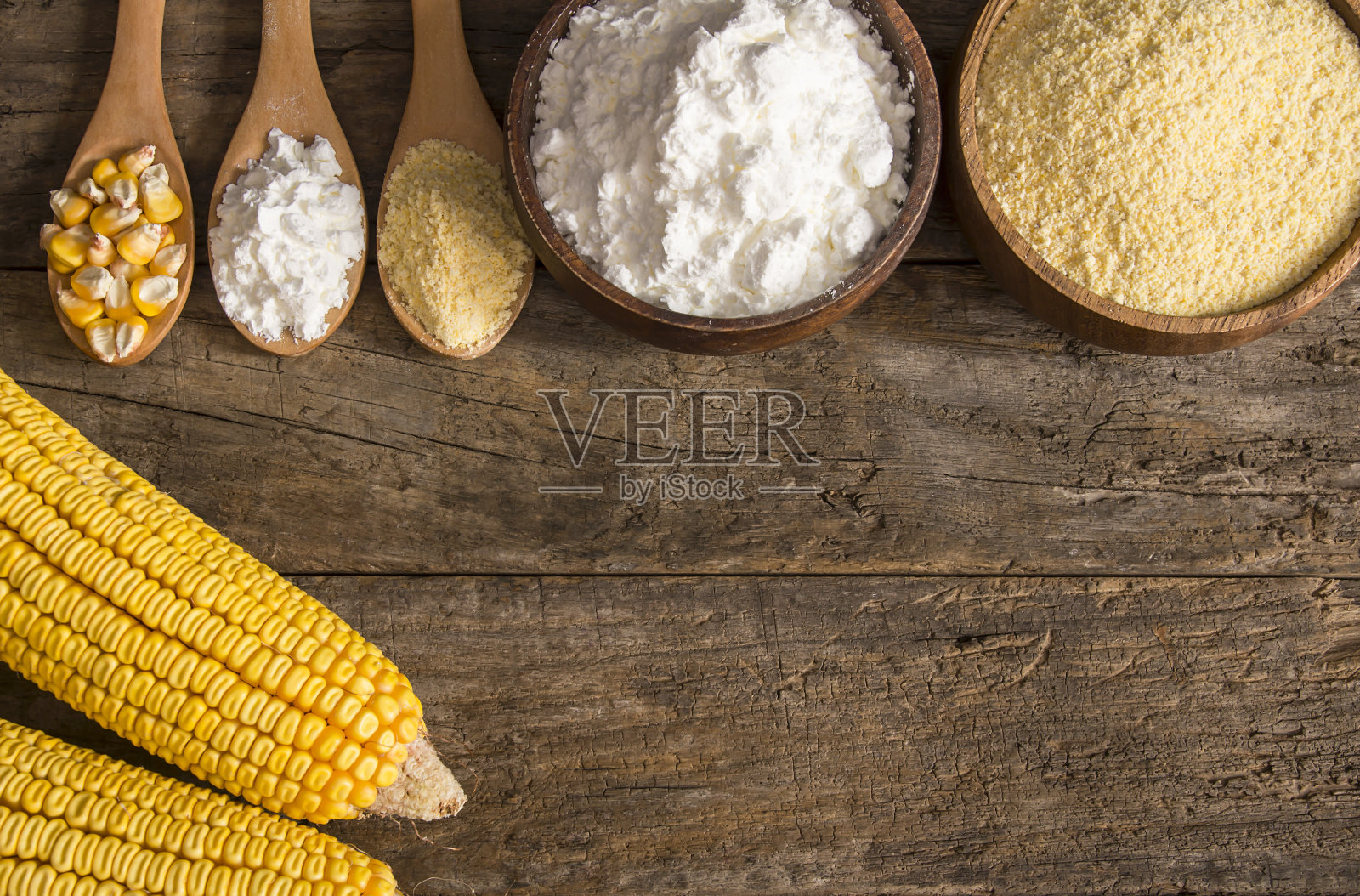 用木碗和木勺盛玉米粉和淀粉，粗玉米粒放在质朴的桌子上。玉米原料的概念照片摄影图片