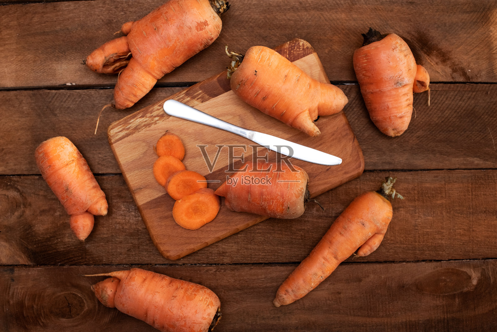 时髦丑陋的有机胡萝卜，从家庭花园床上谷仓的木头桌子，澳大利亚种植。Color-toning应用效果。照片摄影图片
