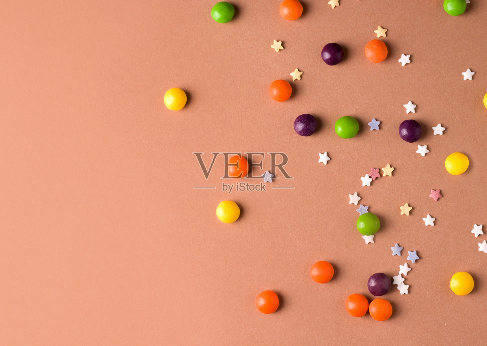 棕色背景上不同颜色的圆糖果。本空间照片摄影图片