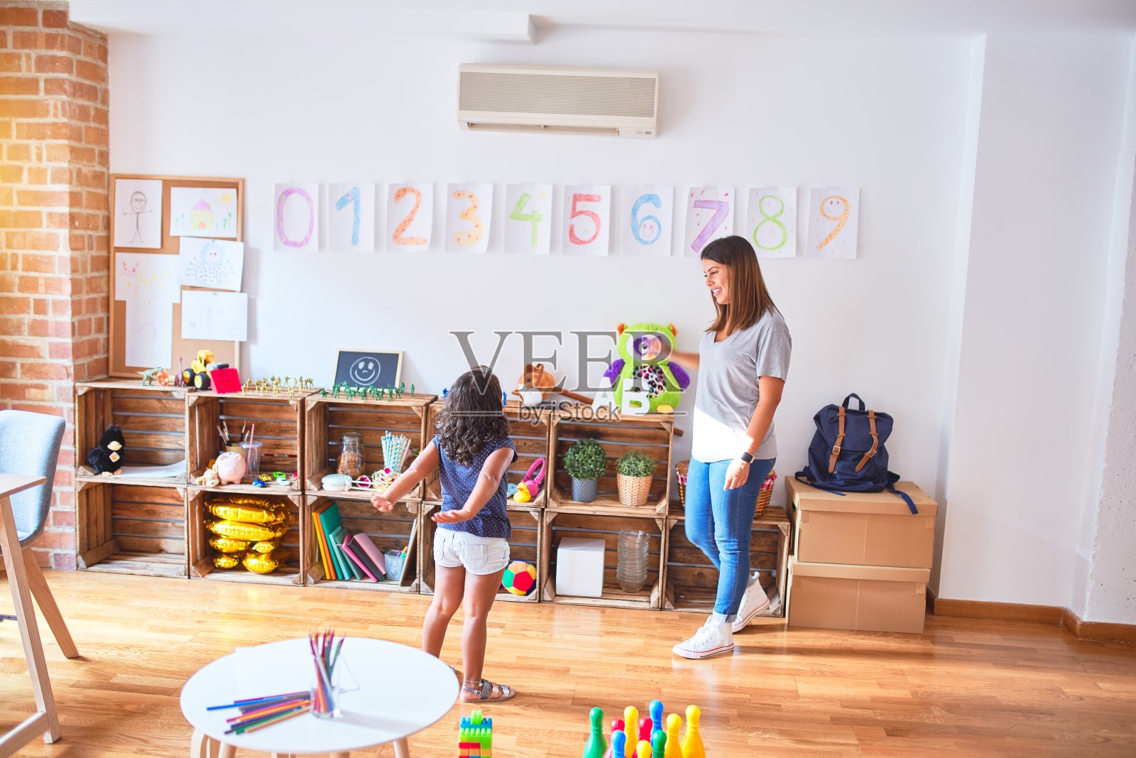 幼儿园里教幼儿数学的美丽女老师照片摄影图片