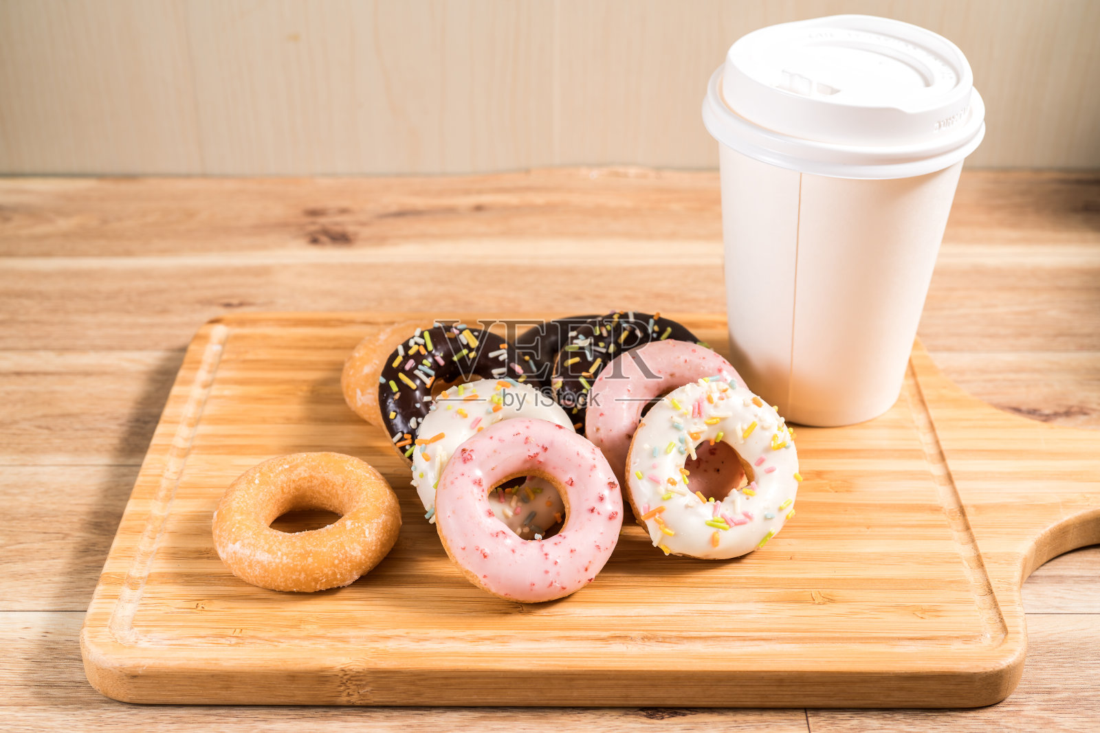 木桌上放着甜甜圈和咖啡。照片摄影图片