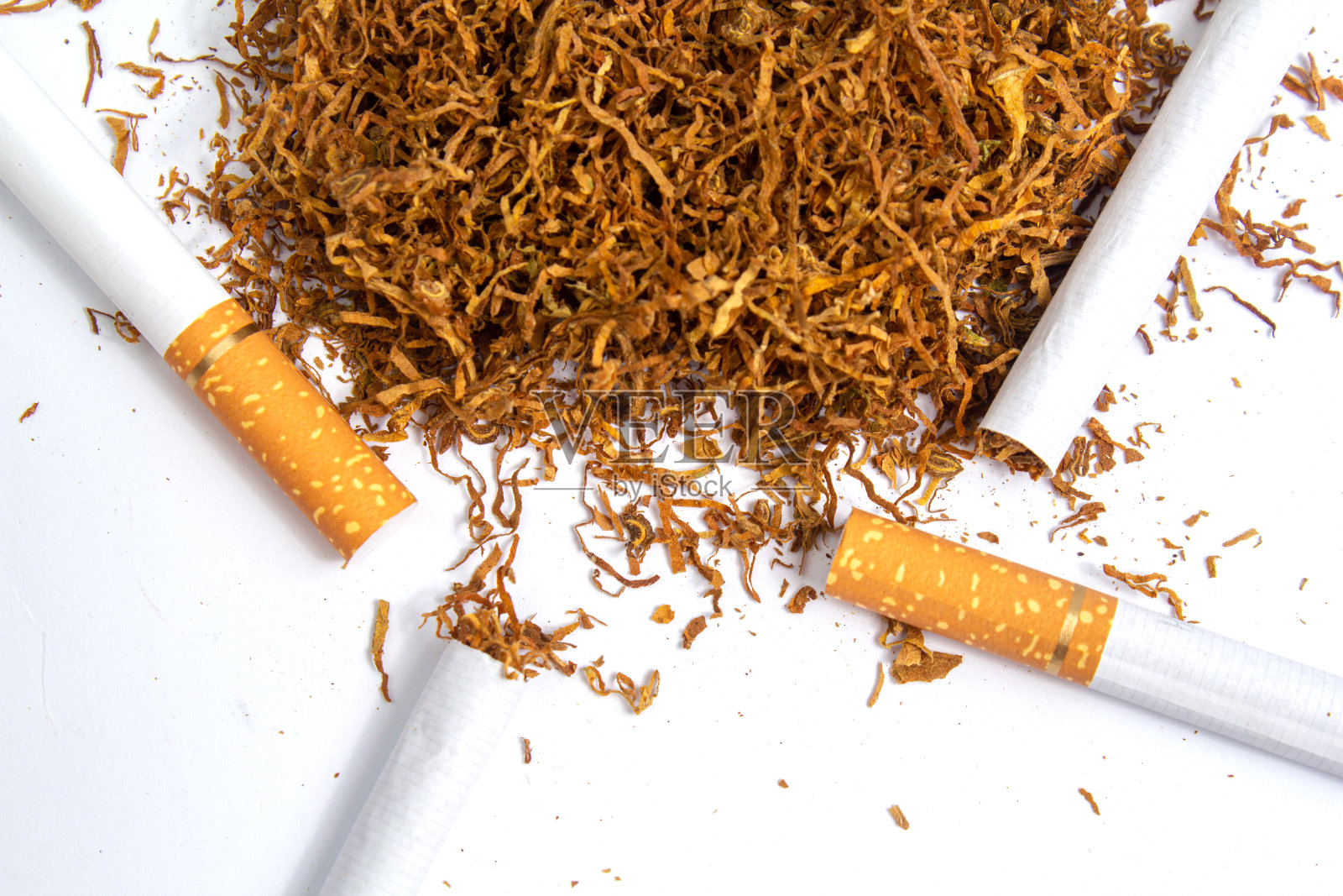 白色背景上的少量烟草和香烟衬垫。隔离照片摄影图片