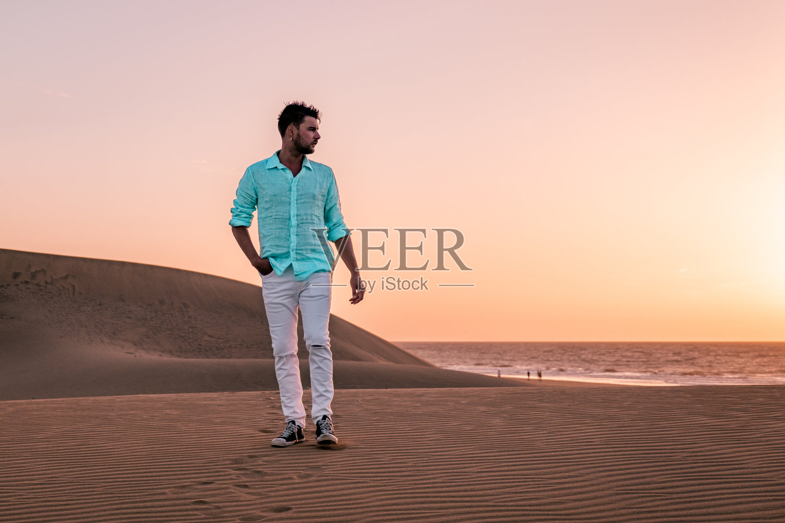 男子在西班牙马斯帕洛马斯海滩散步照片摄影图片