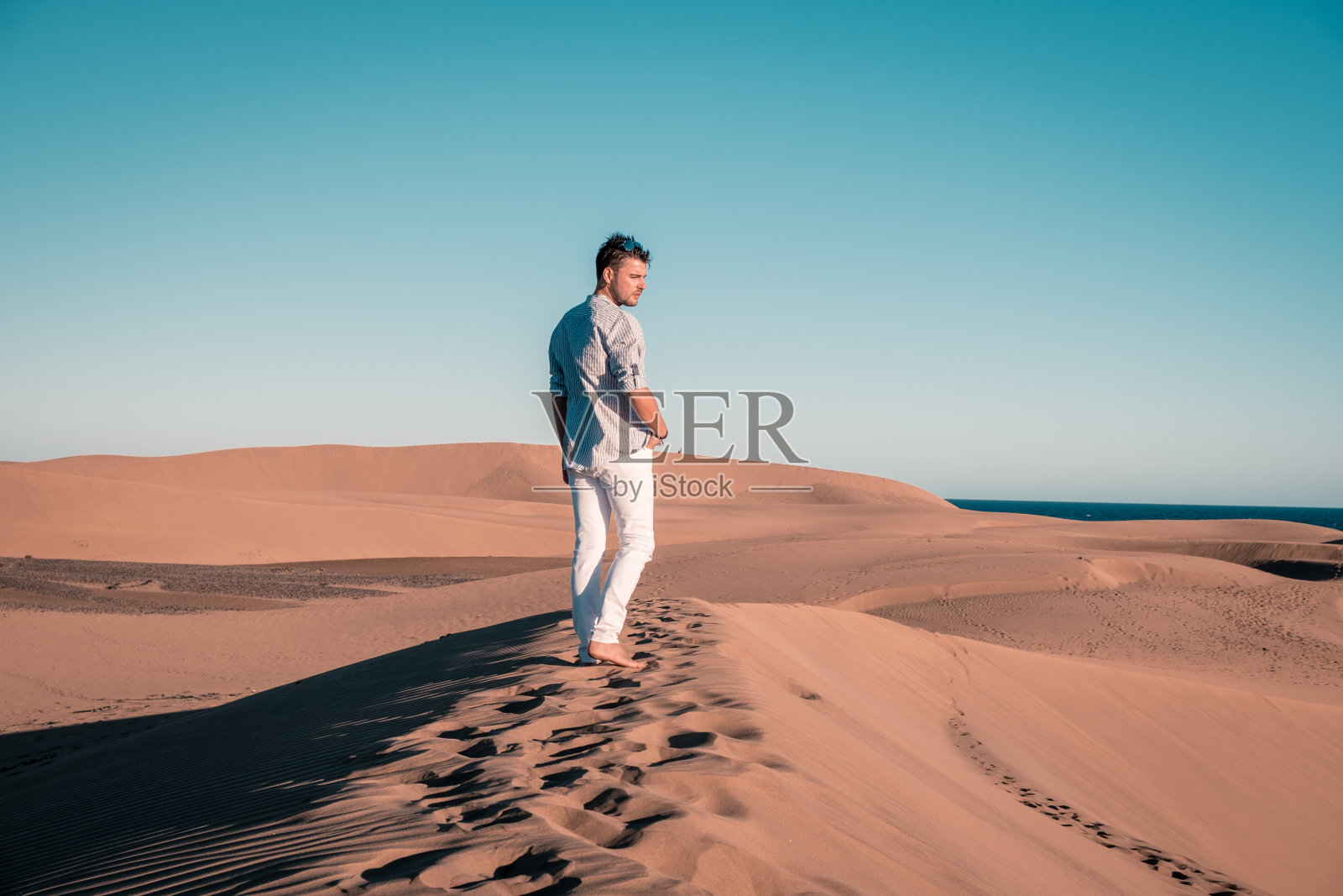 男子在西班牙马斯帕洛马斯海滩散步照片摄影图片