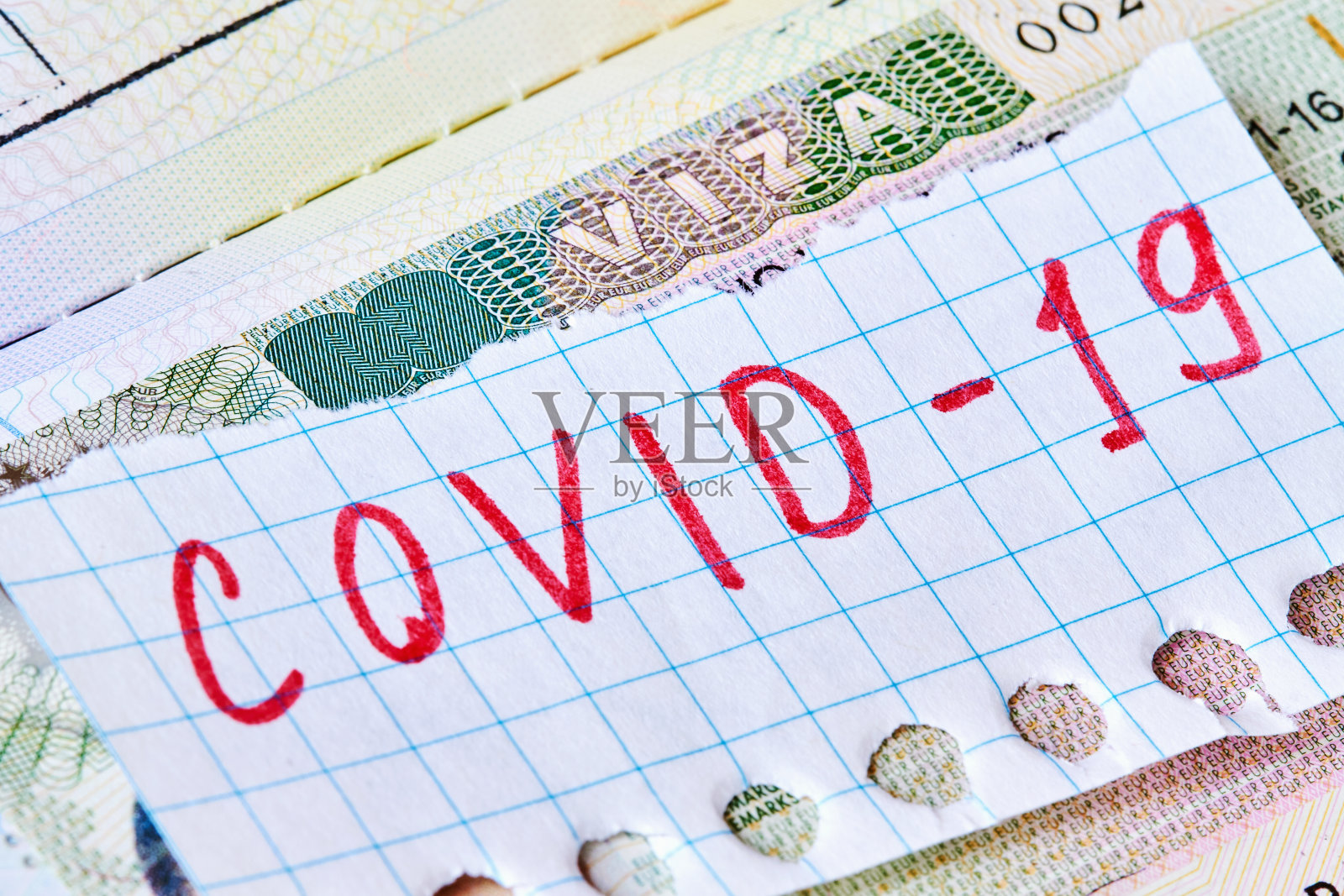 COVID-19冠状病毒大流行与旅游概念。注意护照上有COVID-19和申根签证。对感染冠状病毒的游客进行边境控制和隔离。照片摄影图片