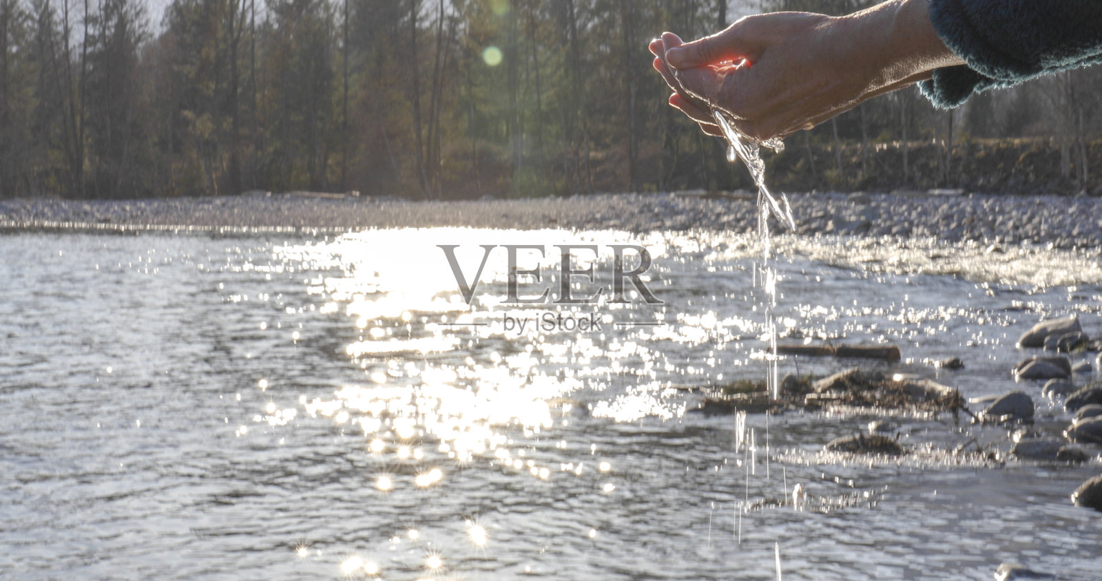 日出时，女性用手舀湖水照片摄影图片