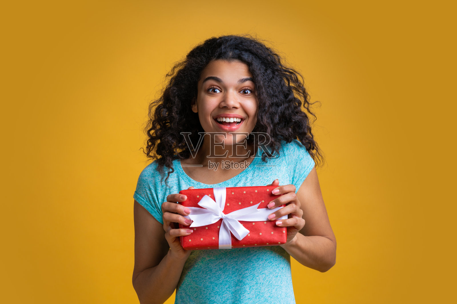 漂亮的年轻非洲裔美国女人手里拿着礼盒照片摄影图片