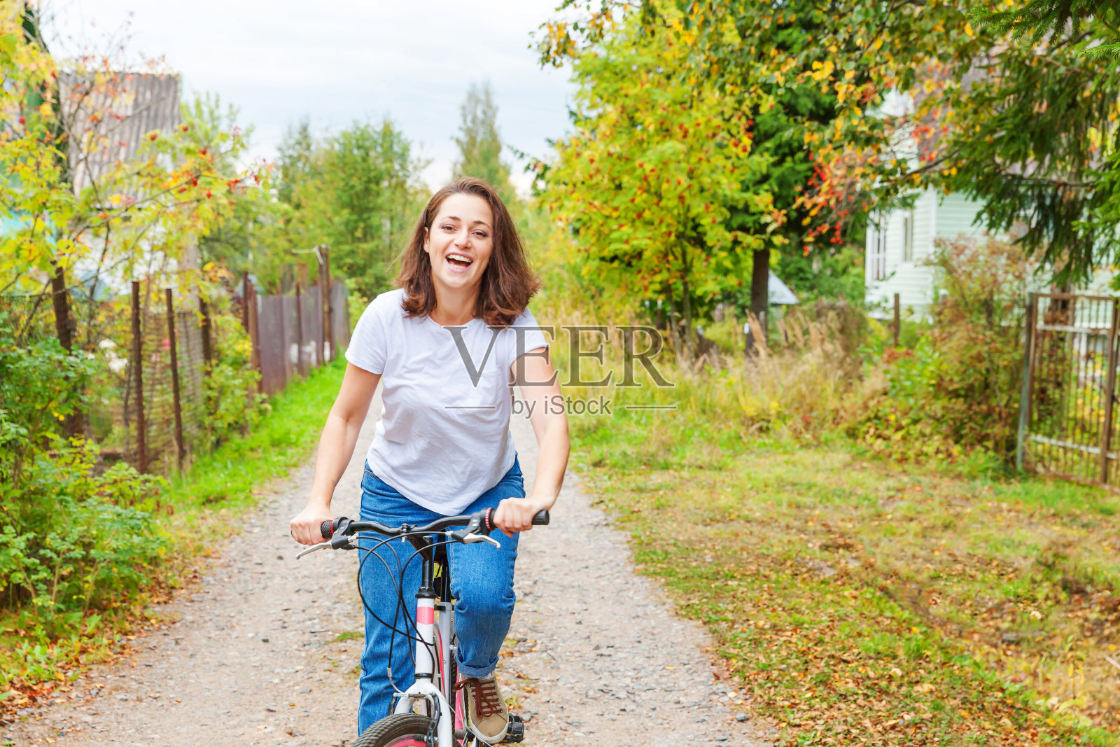 年轻女人在夏日城市公园户外骑自行车。活力人群。时髦女孩放松骑行。夏日骑车上班。自行车与生态生活方式概念照片摄影图片