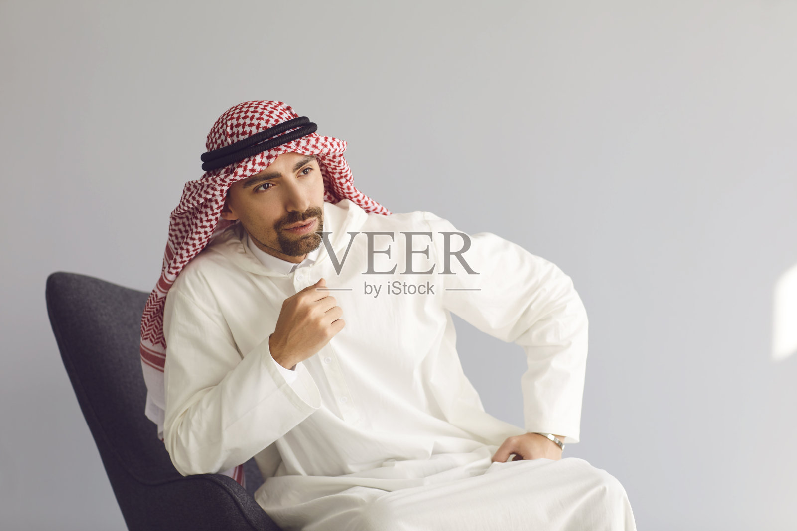坐在椅子上思考，抬头看的沉思阿拉伯商人照片摄影图片
