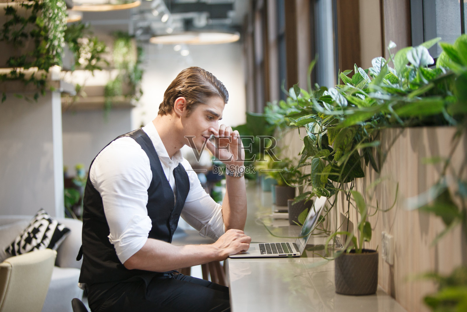 在共享办公空间的柜台上用笔记本电脑进行创业的商人照片摄影图片