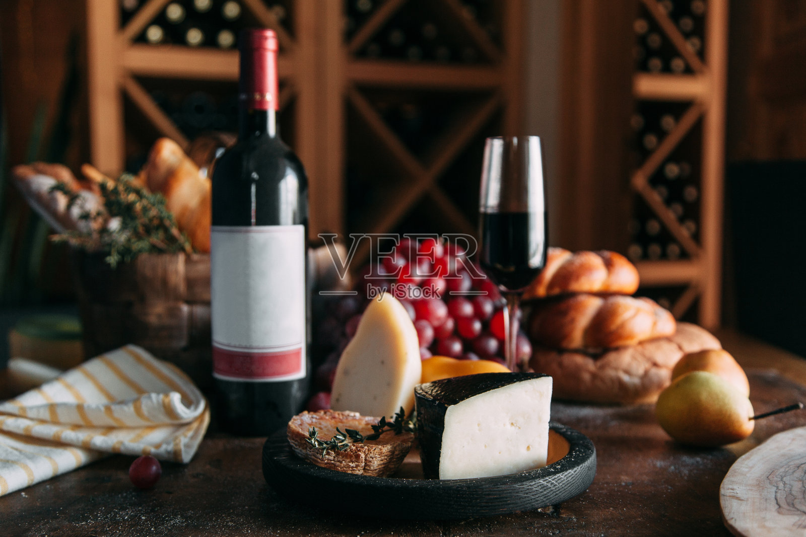 搭配奶酪、葡萄酒和面包。一片帕尔玛干酪和一瓶葡萄酒。照片摄影图片