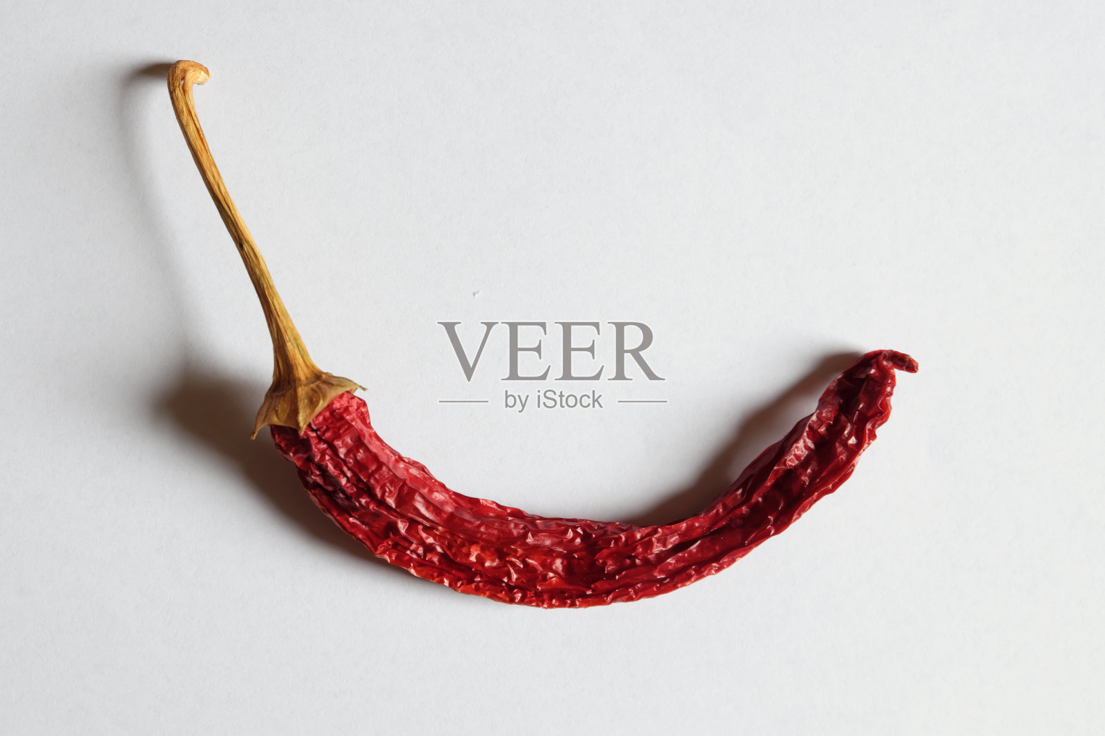 白背景上一个红辣椒。照片摄影图片